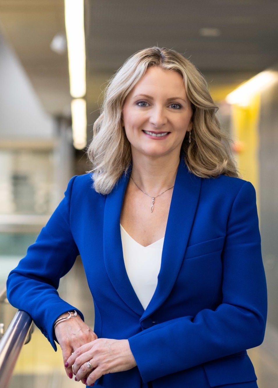 Rebecca Cain stood on 2nd floor of the Design Building in a blue suit